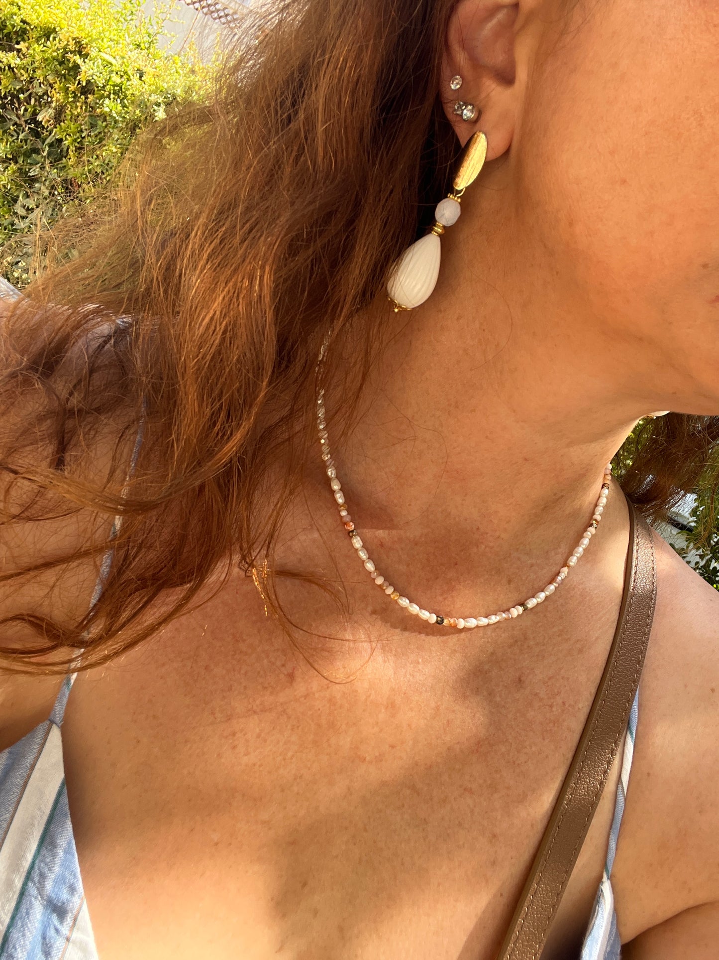 je porte les boucles d oreilles blanches et le collier ras de cou en perles blanches et dorée