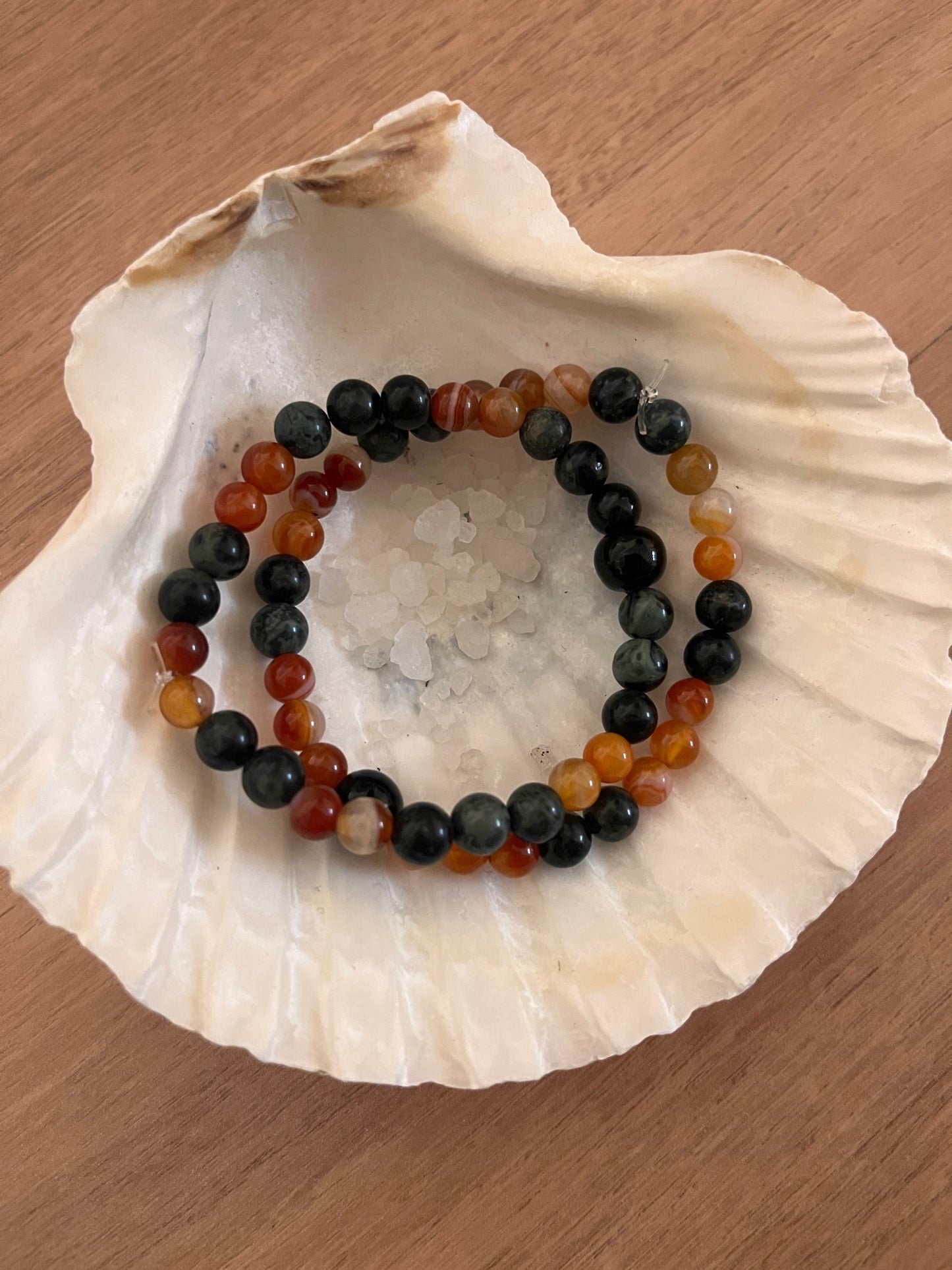 2 bracelet en pierre naturelle de cornaline et de jaspe kambaba posés dans une coquille st jacques