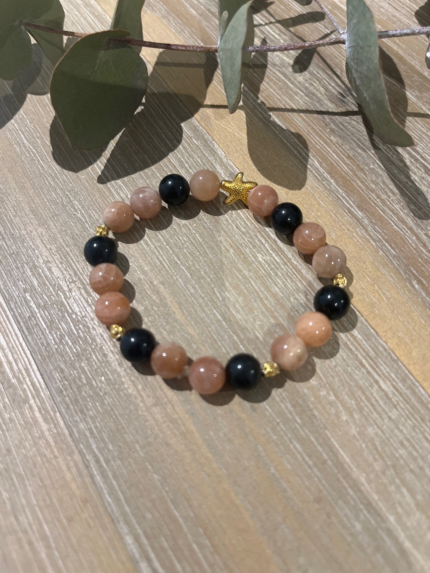 bracelet en pierre de soleil et de tourmaline avec des connecteurs doré étoile de mer et boules