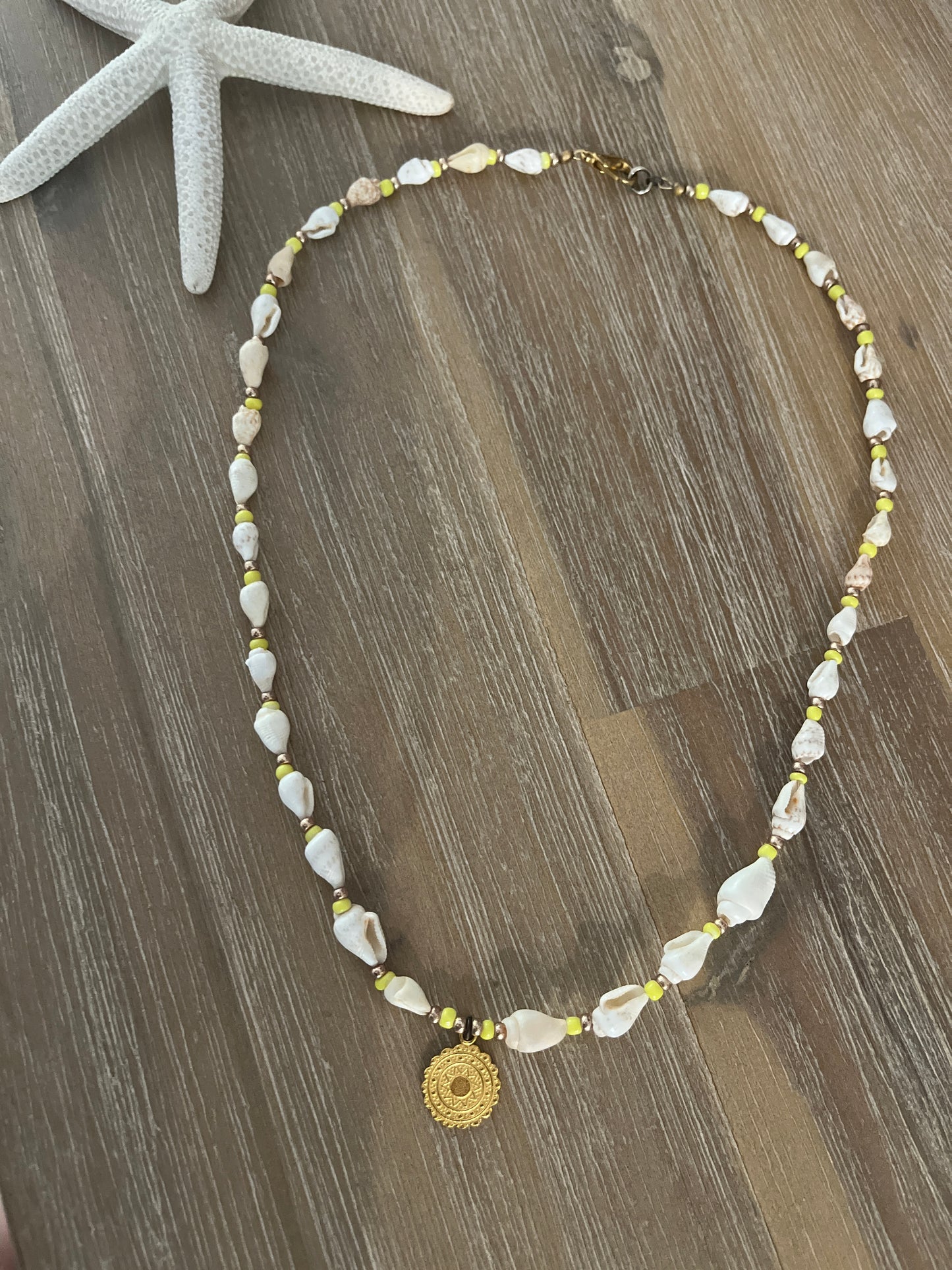 collier en perles de coquillages et pendentif médaillon doré