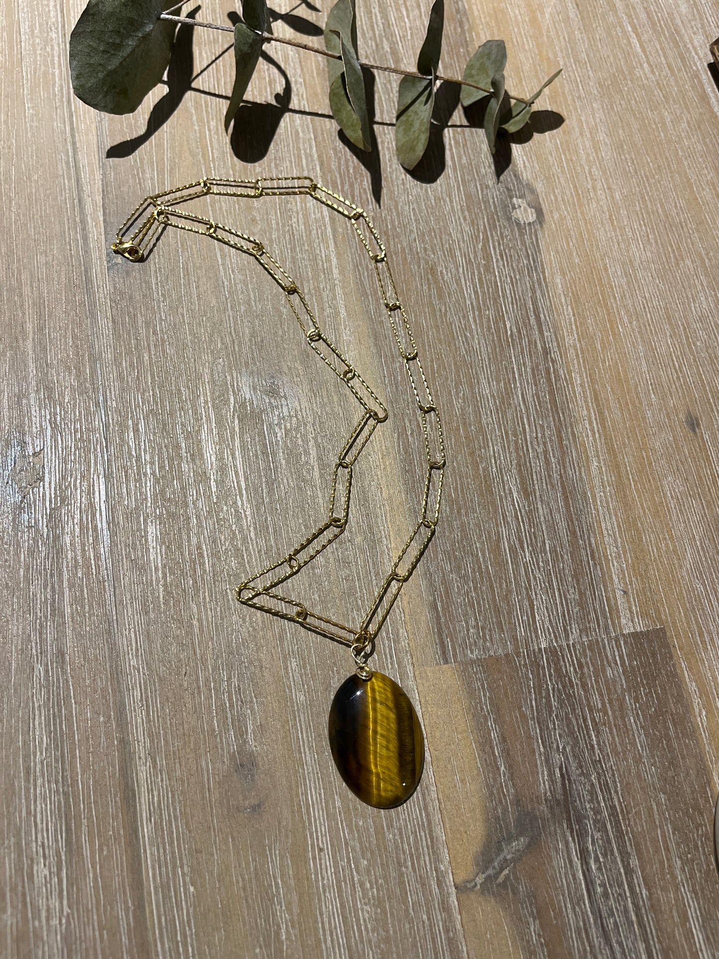 collier chaîne trombone doré et son pendentif ovale oeil de tigre