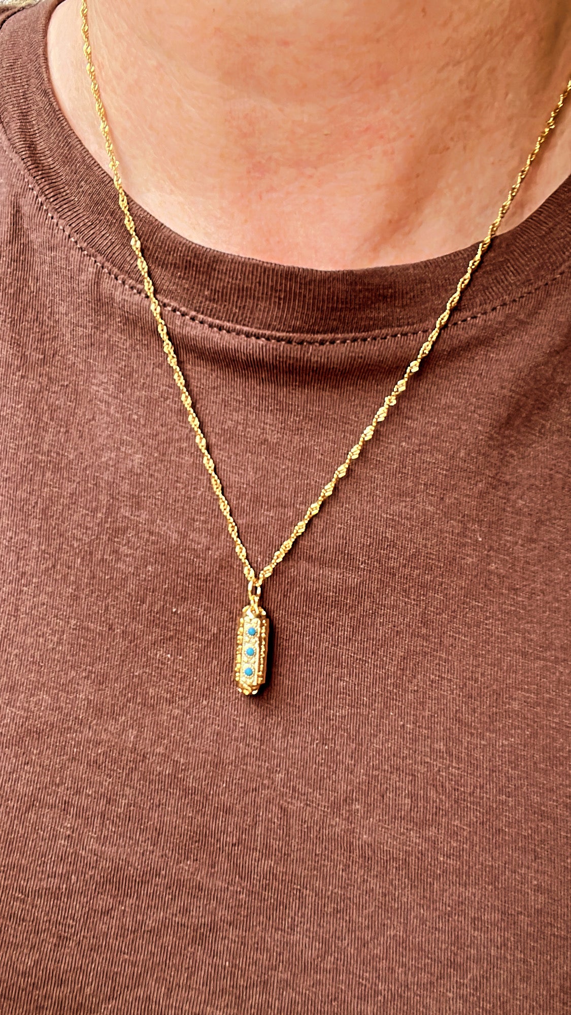 collier doré avec son pendentif porte bonheur