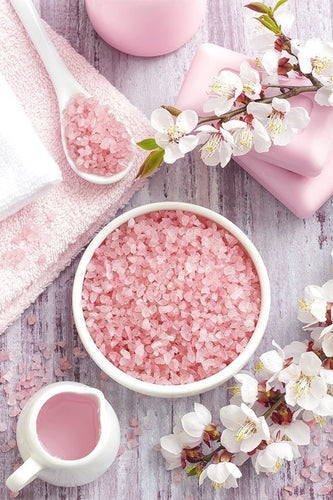 sels de bain d'Himalaya dans une coupelle branches de cerisier serviettes de toilettes lait pour le corps