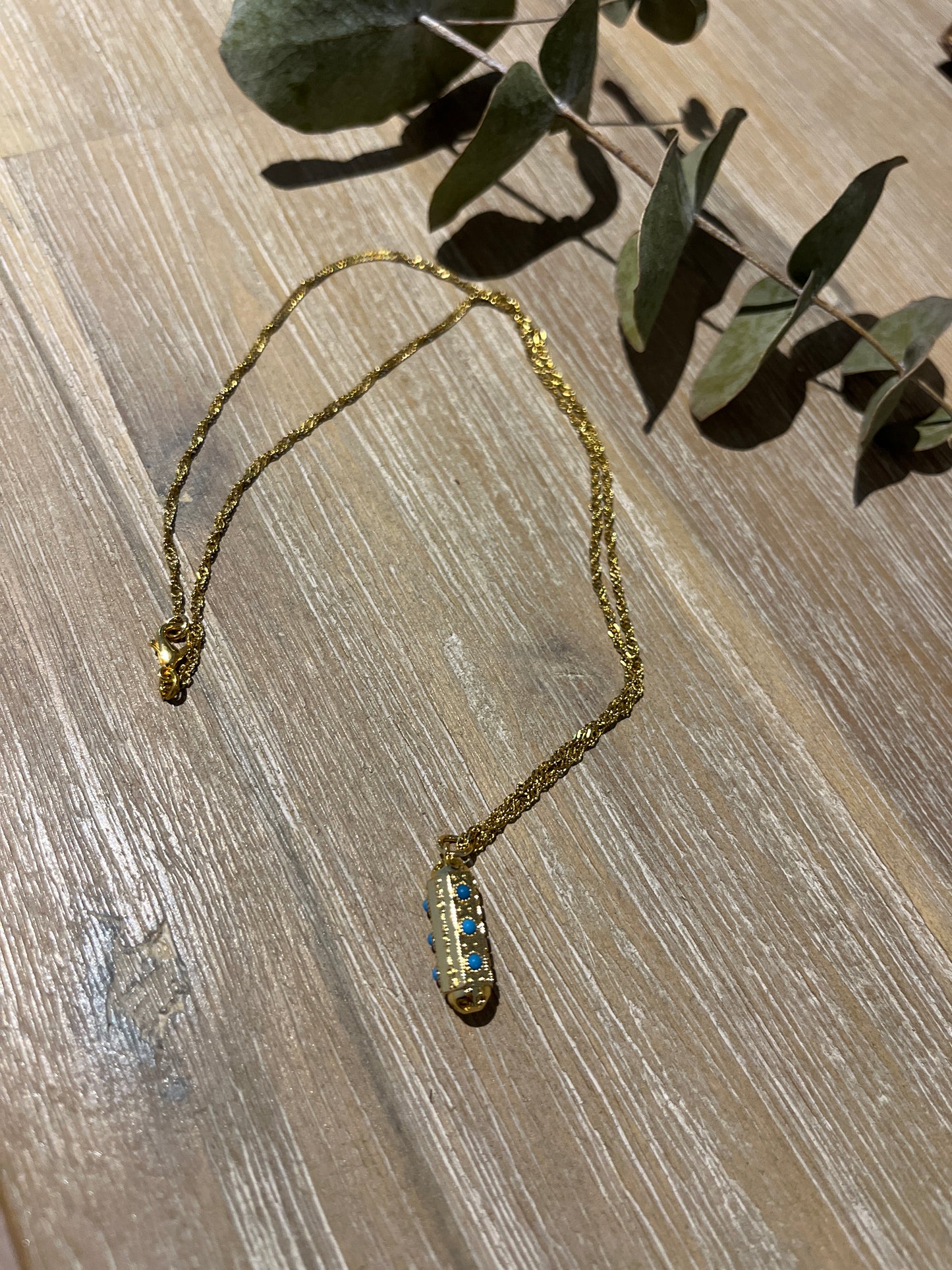 collier doré avec son pendentif porte bonheur