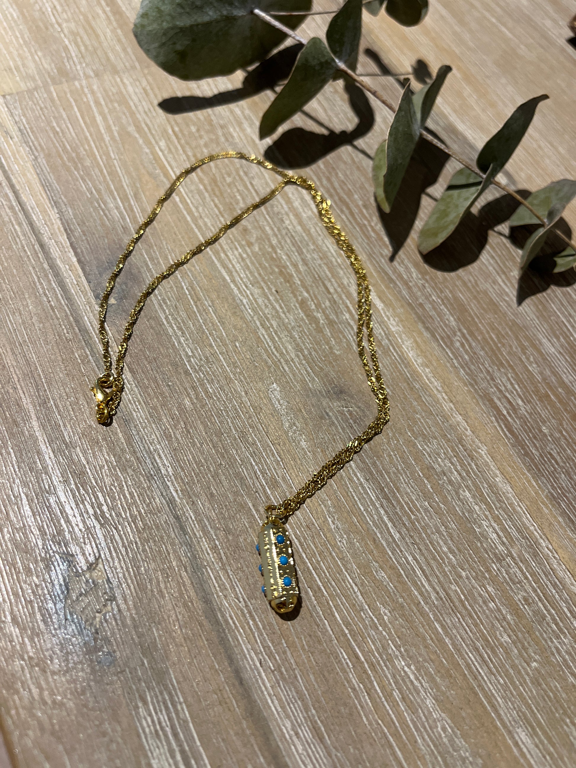 collier doré avec son pendentif porte bonheur