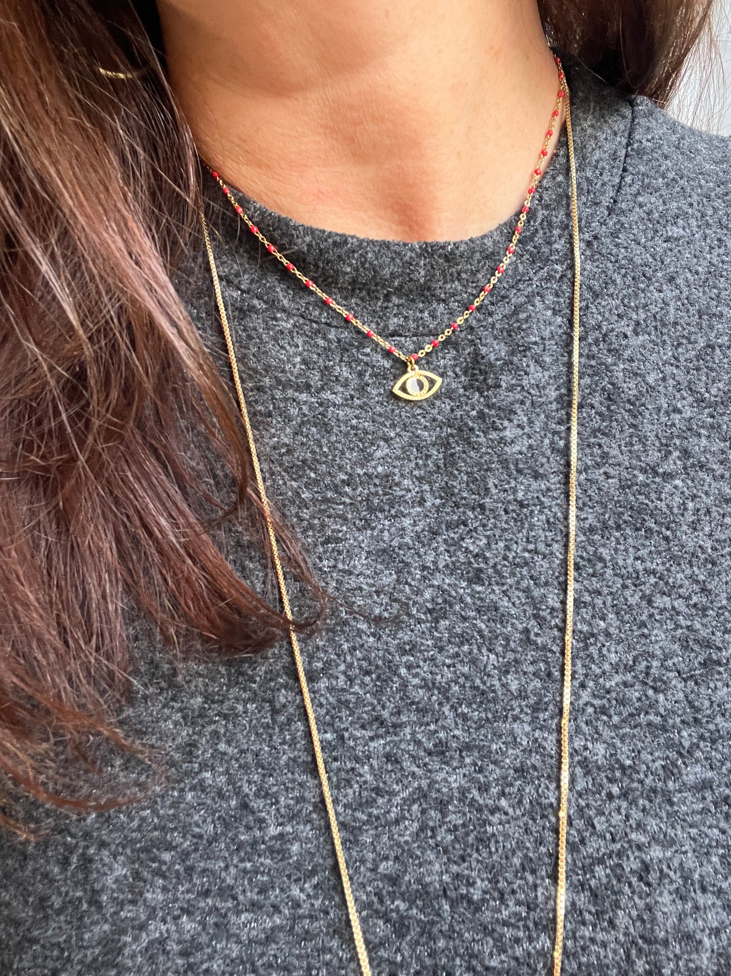 Collier acier inoxydable chaîne doré et rouge pendentif oeil noir.